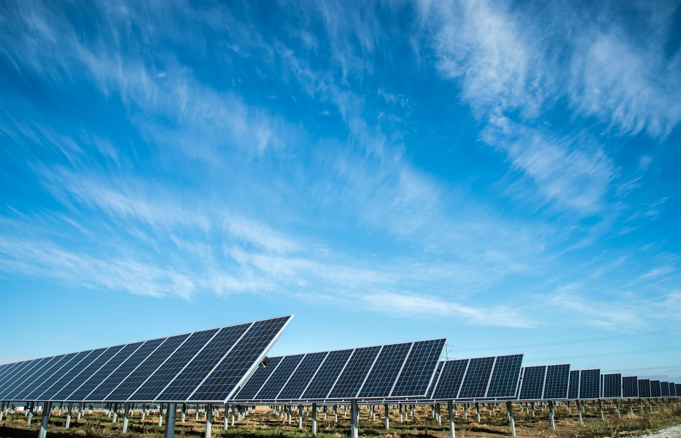 A large-scale solar panel array under open skies, representing the UAE's energy transition and the move toward grid-scale renewable power.